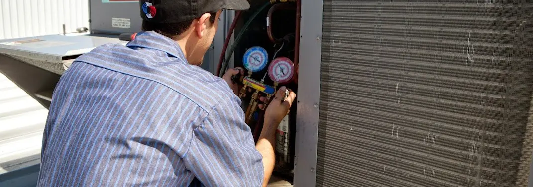 HVAC technician servicing a condenser unit in West Melbourne