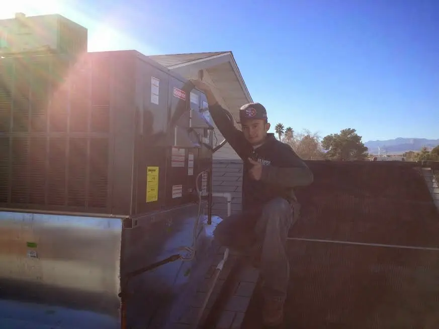 HVAC technician performing AC Tune-Up on a rooftop unit in West Melbourne